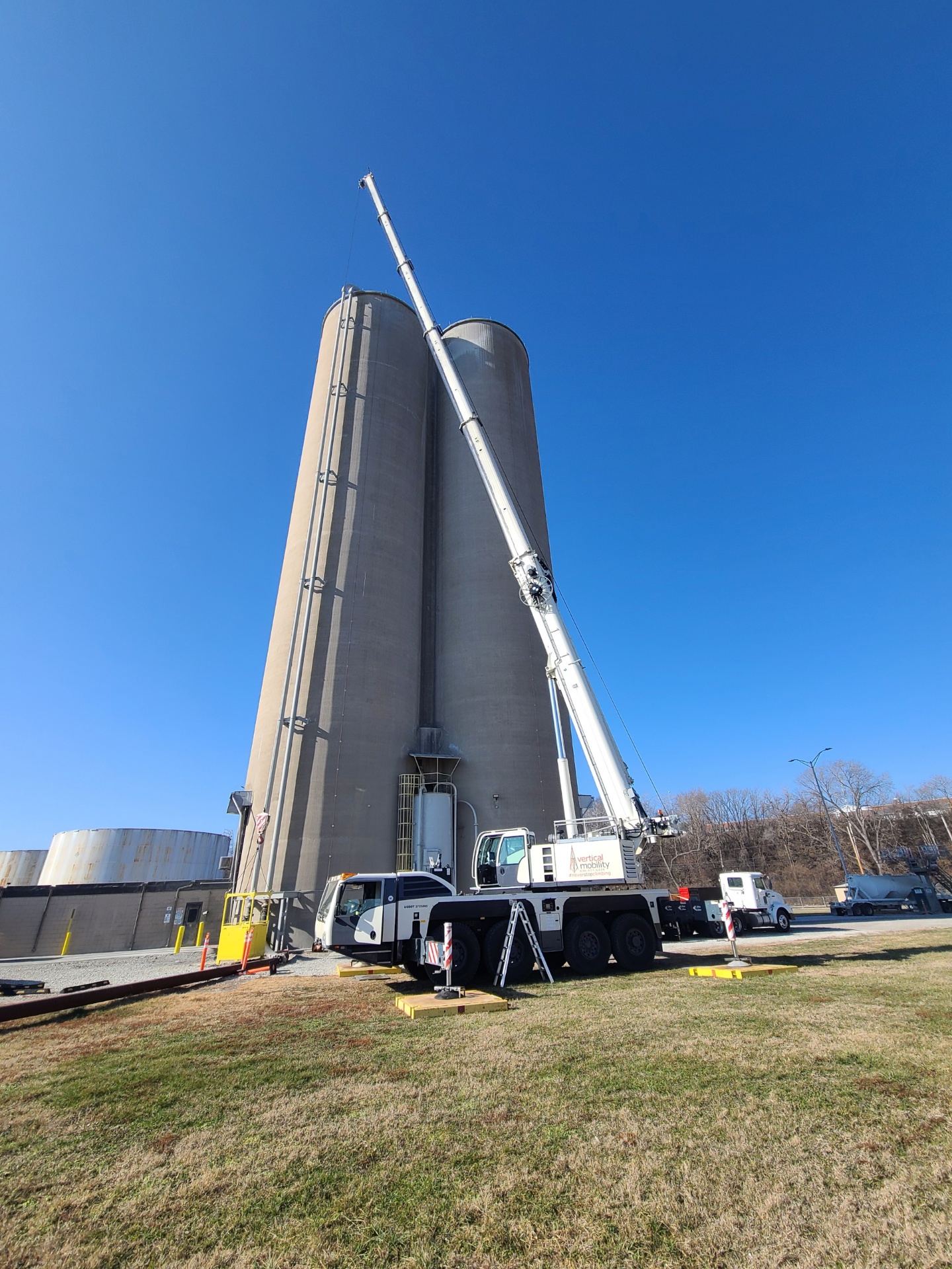 VMC all-terrain crane performing lift at industrial silo